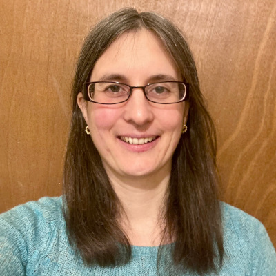 Headshot of Heather Turner. She is a white woman in her 40s with long dark hair and wears glasses.