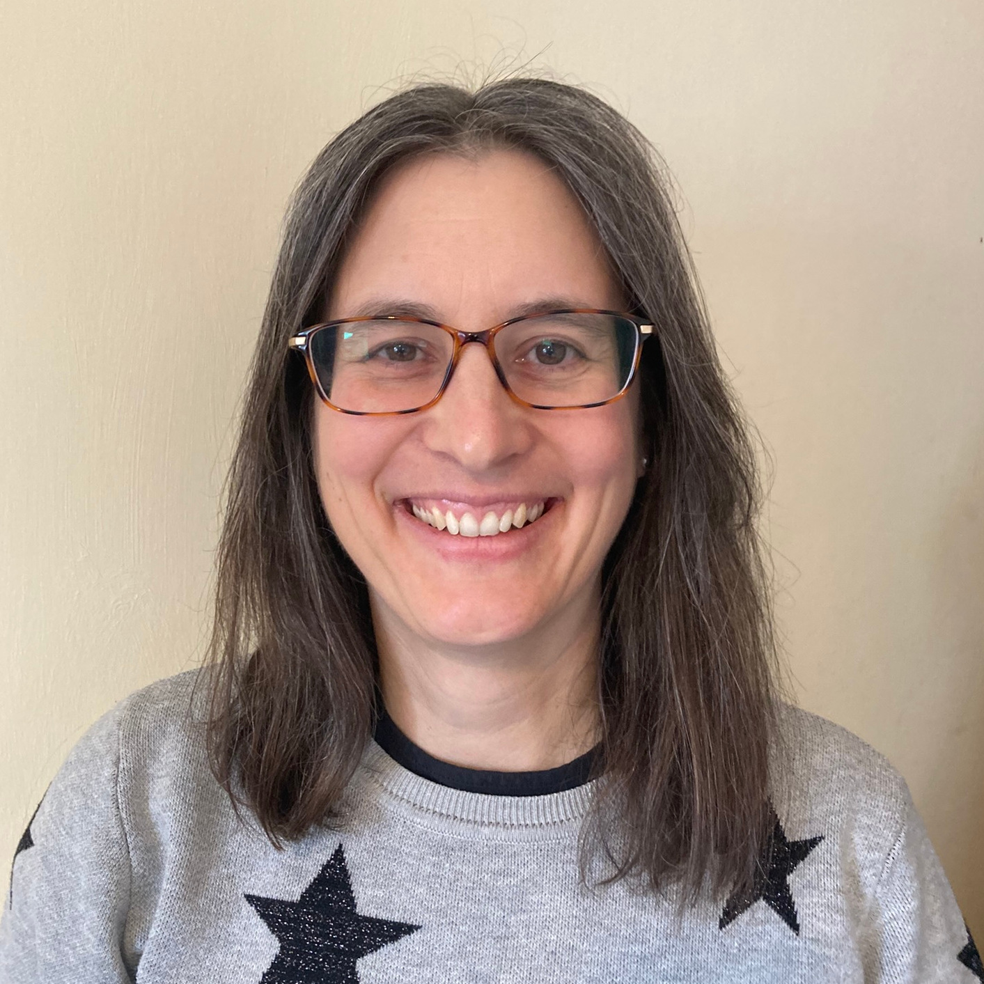 Headshot of Heather Turner smiling for the camera. She is a middle-aged white woman with dark, shoulder-length straight hair and wears glasses.
